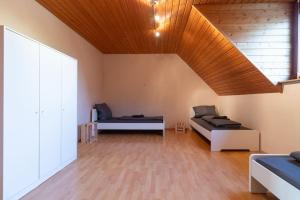 - un salon avec deux lits et un plafond en bois dans l'établissement Großes Haus mit 4 Schlafzimmer, 