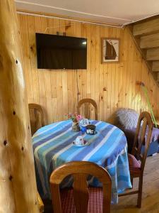 Zimmer mit einem Tisch mit einem blauen und weißen Tischtuch. in der Unterkunft Cabañas León in Ancud