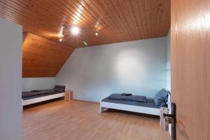 a room with two beds and a wooden ceiling at Traumhaus nähe Mainz I 12 Betten I 4 Schlafzimmer I Terrasse I 200m2 I Garten in Weinolsheim