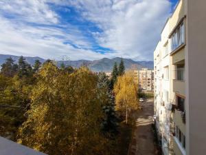 einen Blick vom Balkon eines Gebäudes mit Bäumen und Bergen in der Unterkunft City Park Apartment in Goze Deltschew