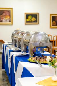 uma fila de mesas com pratos de comida em Rovi Plaza Hotel em Serra Negra