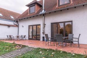 a patio with chairs and tables on a house at Traumhaus nähe Mainz I 12 Betten I 4 Schlafzimmer I Terrasse I 200m2 I Garten in Weinolsheim