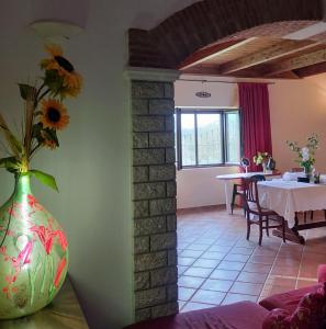 un jarrón con flores en una habitación con mesa en Al Boschetto, en Melizzano
