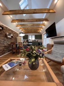 uma sala de estar com uma mesa com um vaso de flores em Altes Fischerhaus in Binz em Binz