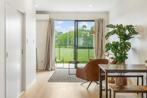a living room with a dining room table and a table at Urban Pulse Townhouse with parking in Auckland