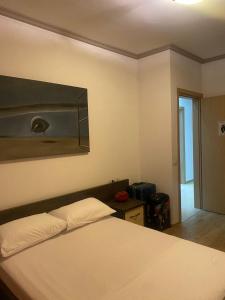een slaapkamer met een wit bed en een spiegel bij Emma & Ella Apartment in Tirana