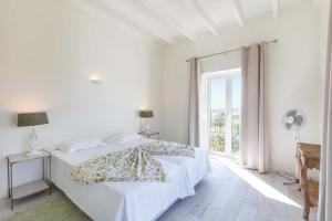 ein weißes Schlafzimmer mit einem Bett und einem Fenster in der Unterkunft Villa Ataboeira in Guia