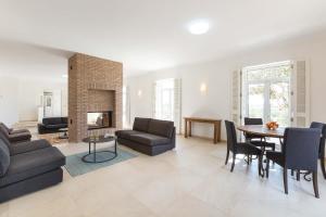 a living room with a couch and a table and a fireplace at Villa Ataboeira in Guia