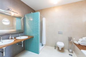 a bathroom with two sinks and a shower and a toilet at Villa Ataboeira in Guia +19 photos