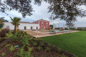 a large red and white building with a green lawn at Villa Ataboeira in Guia