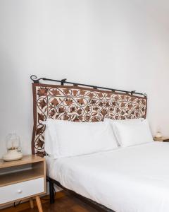 1 dormitorio con cama blanca y cabecero de metal en Belle Arti Zen Apartment, en Roma