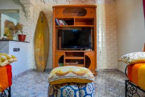 a living room with a tv and a entertainment center at Chez Stef Taghazout in Taghazout