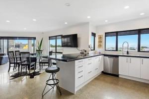 a kitchen and dining room with a table and chairs at Freeman Escape with garage parking in Auckland