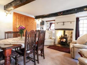 a dining room with a table and a fireplace at Castle Lodge in Keswick