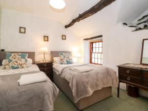 1 dormitorio con 2 camas y ventana en Castle Lodge, en Keswick