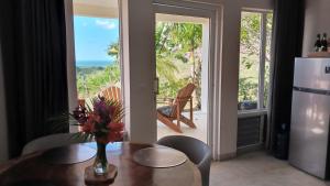 a dining room with a table and a view of the ocean at Domaine Vista Linda La casita del Loma Vista Mar in Río San Juan