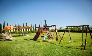 due bambini che giocano su un'altalena in un parco di ISA-Residence with swimming-pool in Vada, apartments with air conditioning and private outdoor area a Vada