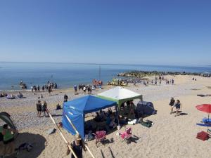 a group of people on a beach with a blue tent at Westpoint Dog Friendly Apartments in West Bay