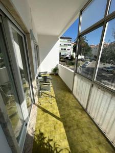 un balcone vuoto con sedie e finestre in un edificio di 5 min Carcavelos Beach a Carcavelos