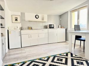a kitchen with white cabinets and a table at Apartament Dotyk - Monte Cassino- Kameralne Poddasze in Sopot