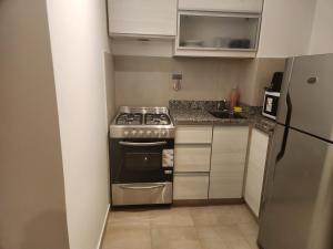 een kleine keuken met een fornuis en een koelkast bij Apart Cabrera y Bulnes 1 in Buenos Aires