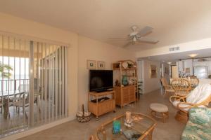 a living room with a couch and a tv and a table at Palms 407 in Islamorada