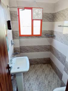 a bathroom with a sink and a window at RajDarbar 