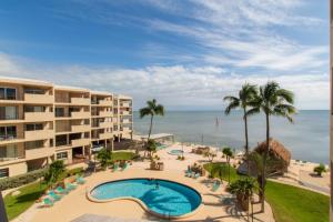 a view of a resort with a swimming pool and the ocean at Palms 407 in Islamorada
