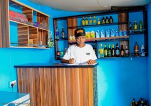 a woman standing behind a bar in a bar at Elios Hotels in Ughelli