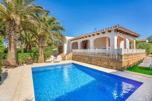 a villa with a swimming pool and a house at Aure Villa con piscina y aire acondicionado! in Cala'n Bosch