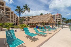 a row of blue lounge chairs on a beach at Palms 417 in Islamorada