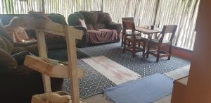 a living room with a couch and a table and chairs at Paradise Nature Tented Camp in Groutfontein