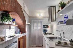 cocina blanca con fregadero y fogones en Casa dellAccademia Apartment in Sorrento Centre, en Sorrento