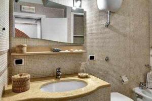 y baño con lavabo, aseo y espejo. en Casa dellAccademia Apartment in Sorrento Centre, en Sorrento