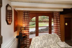 um quarto com uma janela e um sofá num quarto em Gentiane Fermette Hautes Vosges em Tendon