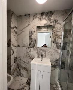 y baño con lavabo blanco y espejo. en ASM London Road Studio Apartments, en Leicester