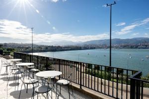 una fila de mesas y sillas en un balcón con vistas al río en Palacio Arriluce Hotel en Getxo