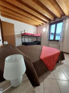 ein Schlafzimmer mit einem Bett mit einer roten Decke in der Unterkunft Il Vagabondo in Volta Mantovana