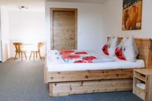 1 dormitorio con cama de madera y almohadas rojas en Gasthof Franziskibad, en Bad Häring