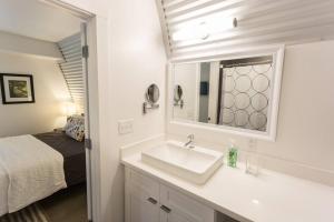 a bathroom with a sink and a mirror and a bed at Moon 101 - Full Moon Suite - 2BR 2 5 Bath + Living in New Orleans +53 photos