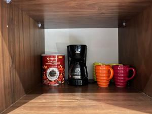 a coffee maker and coffee cups in a cupboard at Habitación Privada Riviera Maya, Playa del Carmen! in Playa del Carmen