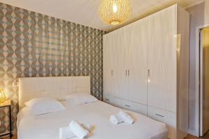 ein Schlafzimmer mit 2 Betten und einem großen Schrank in der Unterkunft Maison Marouette - Welkeys in Aytré
