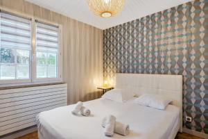 ein Schlafzimmer mit einem Bett mit zwei Kissen darauf in der Unterkunft Maison Marouette - Welkeys in Aytré
