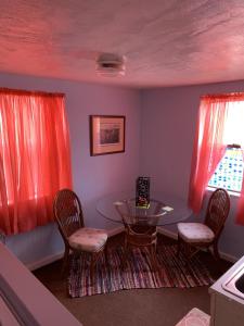 a dining room with a glass table and chairs at Break Side Studio #5 apts in North Camellia Acres