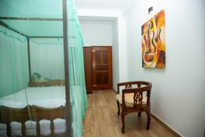 a bedroom with a bunk bed and a chair at Manel Villa in Ahangama