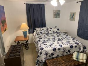 1 dormitorio con 1 cama y 1 mesa con lámpara en Beach Side Studio #2 apts, en North Camellia Acres