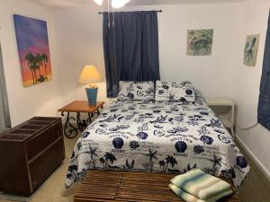 1 dormitorio con 1 cama y 1 mesa con lámpara en Beach Side Studio #2 apts, en North Camellia Acres