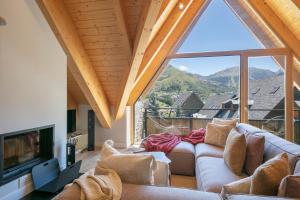 a living room with a couch and a large window at Luderna - Duplex Corilha in Gessa