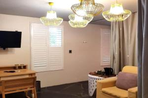 a living room with two chandeliers and a couch at Concierge Hotel in Durban