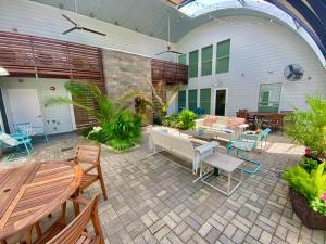a patio with a couch and tables and chairs at Moon 201 - Crescent Moonset Suite - 1BR - 1 Bath in New Orleans